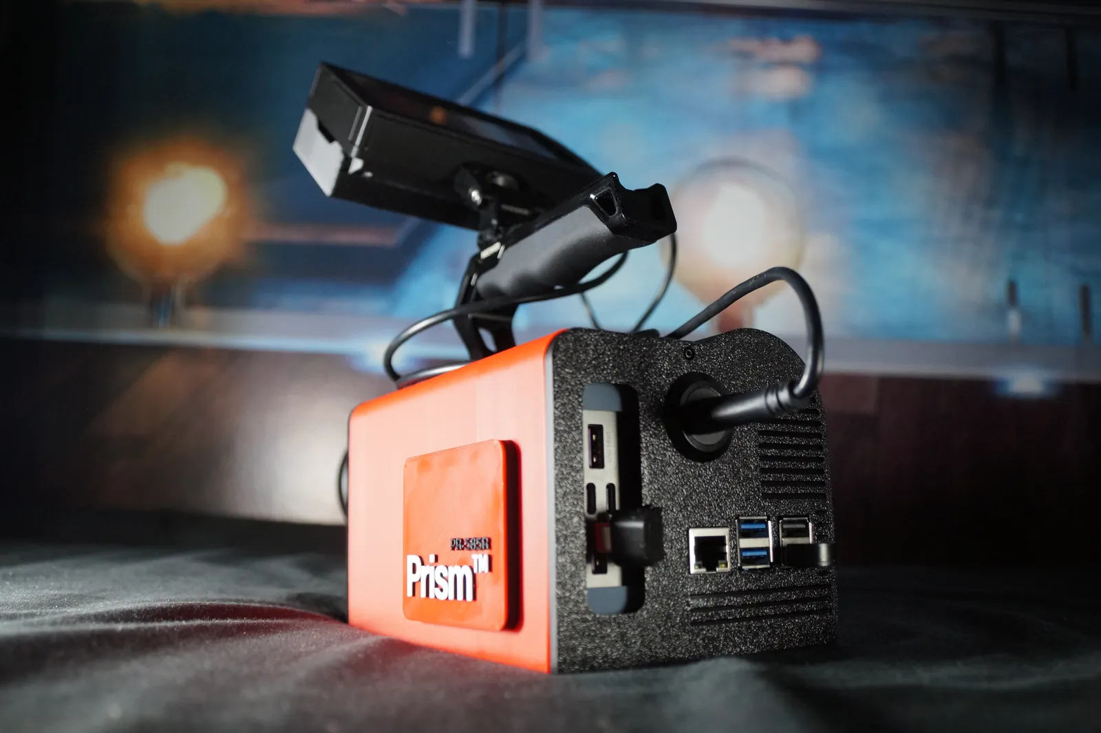The PR-585R from behind in a studio, showing its red side panel with the Prism badge and the ports on its black rear